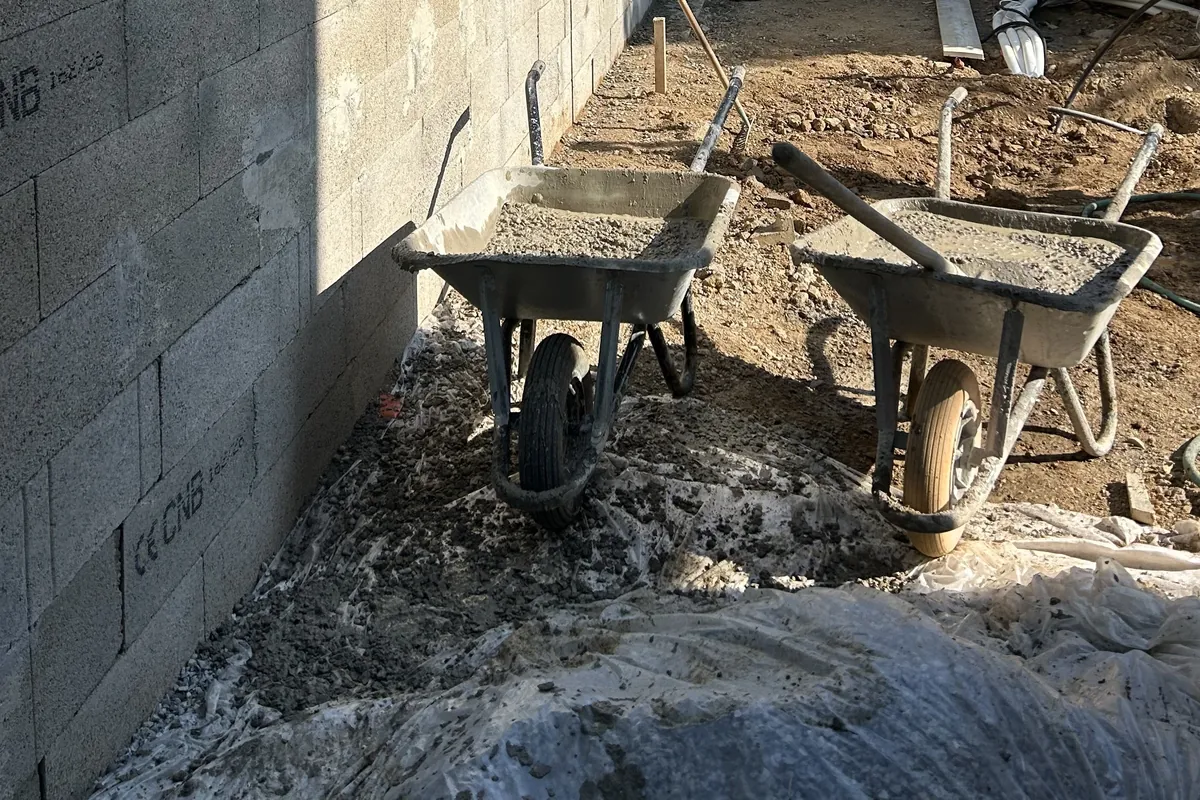 Brouettes de béton au pied du mur de soutènement en cours, Murato