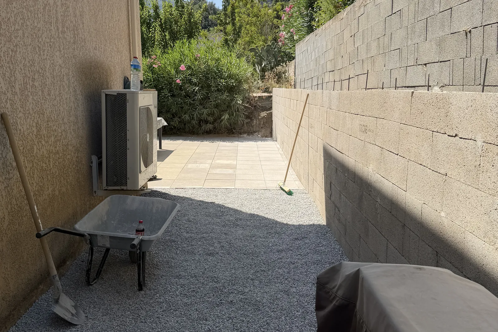 Cheminement dallé et gravier décoratif le long de la maison, au pied du mur de soutènement, Murato